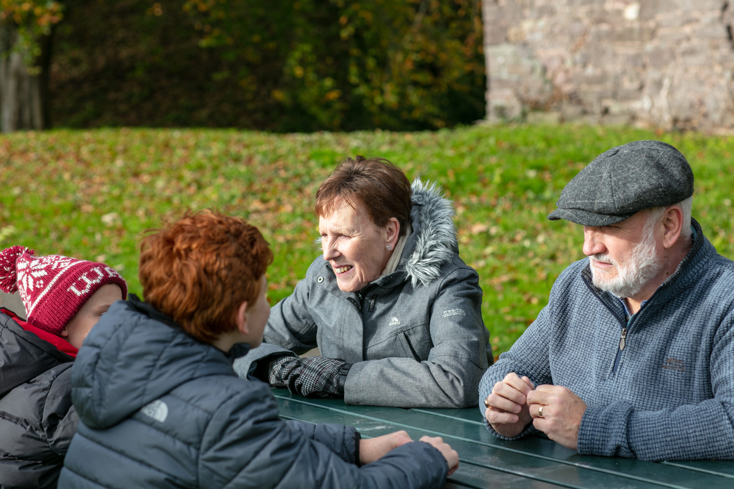 family sitting around a bench smiling