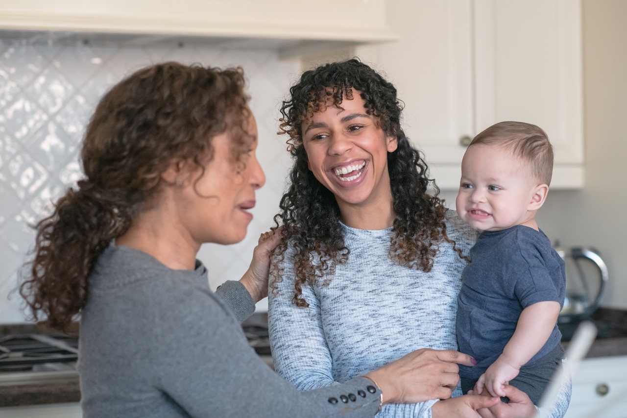 foster carer, parent and child in a kitchen